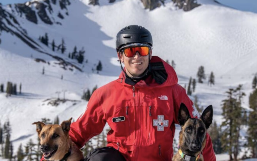 Ski Patroller Ben Stone poses with his avalanche rescue dogs Kaya and Ahsoka at Palisades Tahoe in Olympic Valley. Credit: Keoki Flagg, 2022. 